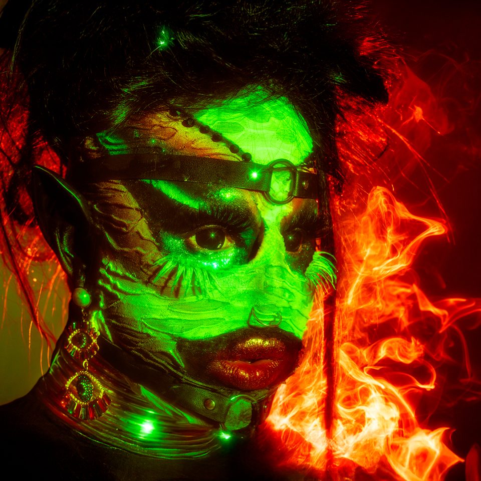 Bold, high-fashion image of a drag queen performer in vibrant lighting London